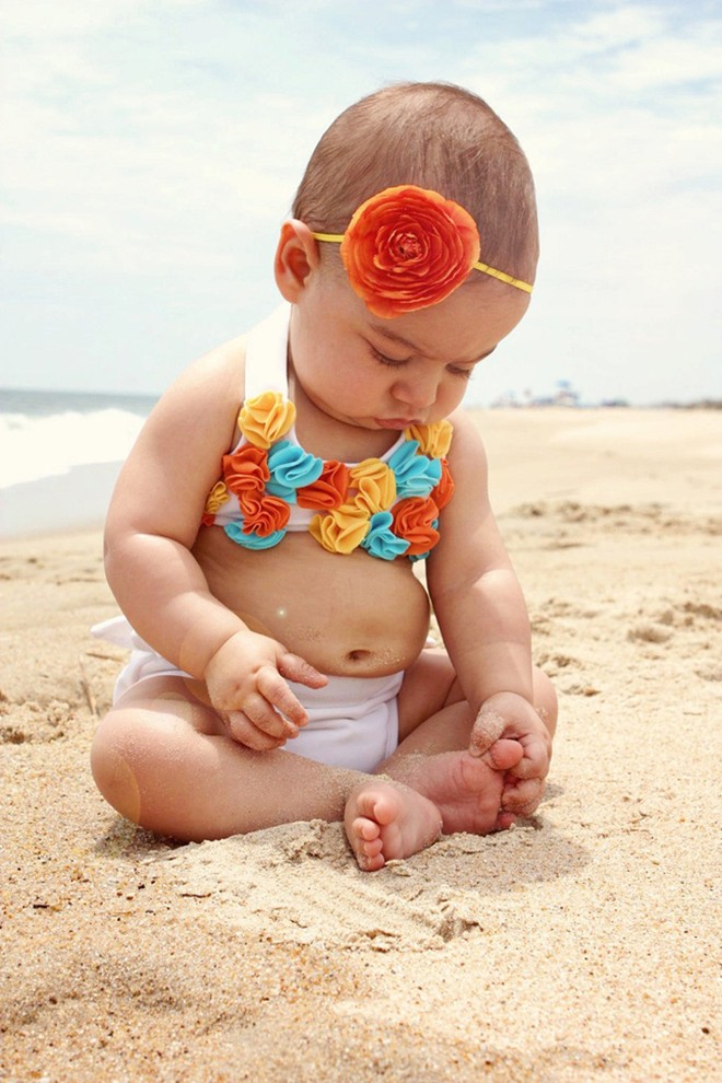 Bikini hoa 3D kèm theo chiếc vòng cài tóc tết bằng một bông hoa to “cộ” giúp cô nhóc trở nên nổi bật giữa biển mùa hè.