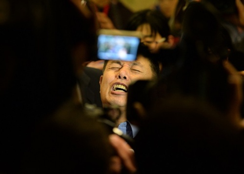 Wen Wancheng, who is the spokesman for the Chinese relatives of passengers from missing Malaysia Airlines flight MH370, reacts as he speaks to the media at the Metro Park Lido Hotel in Beijing on March 20, 2014.
