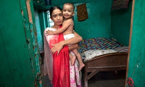 Labon  27 tuổi, làm việc tại một nhà thổ ở Jessore, Bangladesh, trong hình là con gái cô và cha của đứa bé là một trong những khách hàng trước đây của cô.