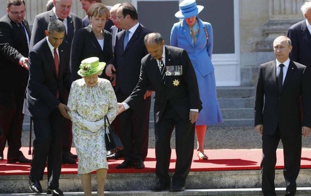 Tháng 6/2014, ông Putin tới Pháp tham dự lễ kỉ niệm 70 năm ngày quân đồng minh đổ bộ xuống bờ biển Normandy, trong thời điểm Moscow và phương Tây căng thẳng vì Ukraine. Ảnh: Tổng thống Putin một mình đứng dạt sang một bên, trong khi nhiều nhà lãnh đạo nước ngoài đang đỡ Nữ hoàng Anh Elizabeth đệ nhị bước xuống các bậc thang.